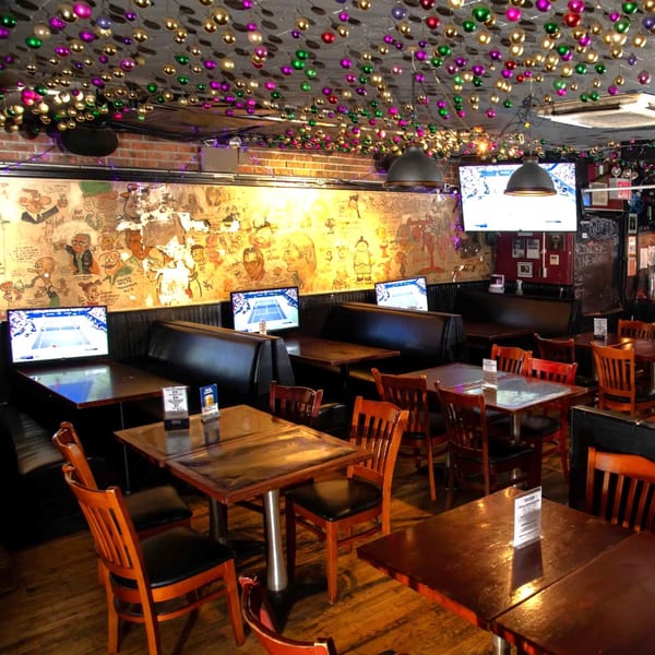 Interior of Overlook sports bar with tables, booths, TVs, and colorful ceiling decorations.