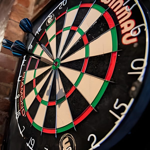 Three blue darts stuck in a dartboard, ready for a game at Overlook sports bar.