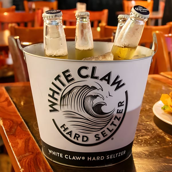 A White Claw bucket filled with ice and several bottles of beer and hard seltzer.