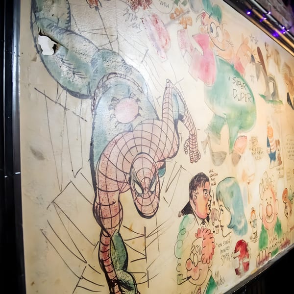 A vibrant, hand-painted mural featuring Spider-Man and various cartoon characters on a wall at Overlook.