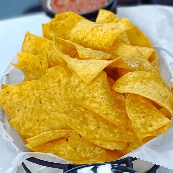 A basket of crispy, golden tortilla chips, ready to be enjoyed at Overlook sports bar.